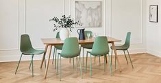 a dining room table with green chairs around it