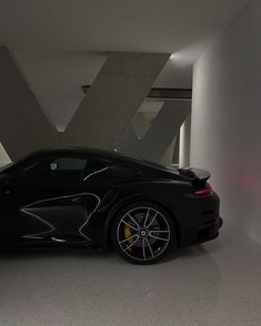 a black sports car parked in a white room