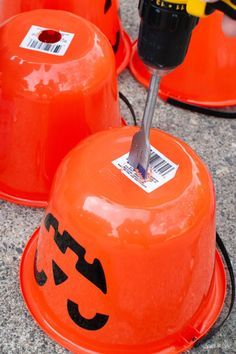 three orange buckets sitting on top of a cement floor