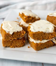 four pieces of cake sitting on top of a white plate with frosting around them