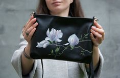 If you are looking for a unique black leather festive handbag, this is it! This small black purse is decorated with 100% hand-painted Magnolia flowers. Light pink Magnolia flowers look very beautiful. Pink flowers painting is made of acrylic paints. After drying, the drawing is fixed at high temperature. Therefore, it becomes resistant to moisture and abrasion. In every work of art I put a part of my soul, heart and emotional content. I really like my work, that's why every thing is so special a Pink Flowers Painting, Magnolia Painting, Small Black Bag, Bag With Flowers, Small Black Purse, Pink Magnolia, Magnolia Flowers, Beautiful Pink Flowers, Black Leather Bag