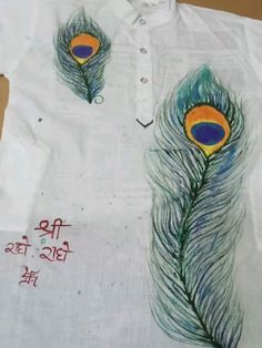 an image of peacock feathers painted on a white shirt with writing written in the middle