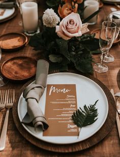 a table setting with place settings, napkins and flowers