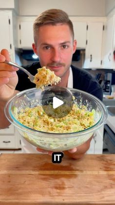 a man holding a spoon full of food in a bowl with the word it on it