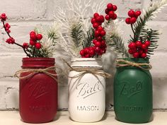 three painted mason jars with red, green and white decorations