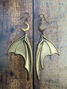 These Large Brass Bat Wing and Crescent Moon Earrings measure approx 4" long. All items made by Serpentine are One-of-a-kind using metals, stones, Ethically Sourced bones and more. I hand make every piece in my home studio in Seattle. If you have any questions about my work please feel free to contact me! *FREE SHIPPING WITHIN THE US* ::Shipping:: Your order will be shipped within 1-3 business days after the payment is completed. I ship USPS priority mail within the US which usually takes 3-5 bu Gold Fantasy Jewelry For Halloween, Gothic Horned Jewelry For Halloween, Fantasy Jewelry For Halloween, Witchy Jewelry For Halloween Festival, Gothic Gold Jewelry For Cosplay, Handmade Gothic Horned Jewelry, Handmade Metal Witchy Earrings, Gothic Horned Metal Jewelry, Fantasy Metal Earrings For Halloween