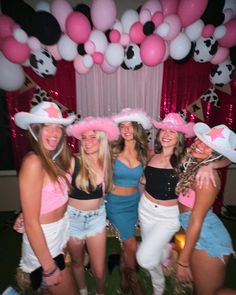 a group of young women standing next to each other in front of a balloon arch