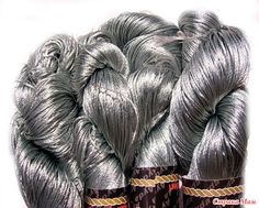 several skeins of silver colored yarn are stacked on top of each other