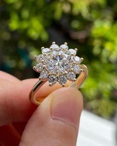 a hand holding a diamond ring in it's left hand