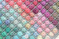 a crocheted blanket with multicolored squares on it