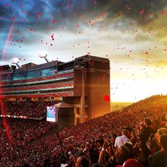 a large stadium filled with lots of people flying kites in the sky above them