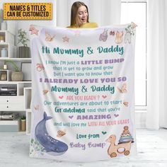 a woman holding up a blanket with the words mommy and daddy written on it in different languages