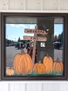 there is a sign that says welcome to all and pumpkins are in front of it