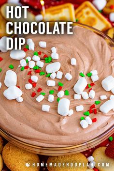 hot chocolate dip with marshmallows and candy canes in the middle surrounded by cookies