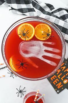 a halloween drink with orange slices and spider legs