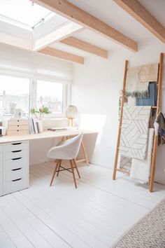 an attic office with white walls and wooden beams