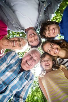 a group of people standing in a circle with their heads together and looking up at the camera