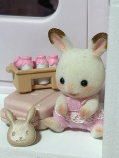 a stuffed rabbit sitting next to a toy oven