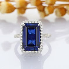 a blue and white ring sitting on top of a table next to some dried flowers