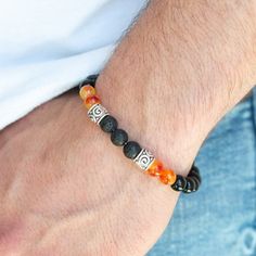 Infused With Ornate Silver Accents, An Earthy Collection Of Glassy Black Beads, Orange Stone Beads, And Black Lava Rock Beads Are Threaded Along A Stretchy Band Around The Wrist For A Seasonal Look. Sold As One Individual Bracelet. Male Bracelets Beads, Male Beaded Bracelets, Mens Stretch Bracelets, Mala Beads Bracelet, Lava Bead Bracelet, Orange Bracelet, Orange Stone, Mens Beaded Bracelets, Lava Bead