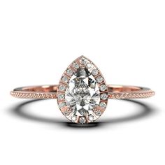 a rose gold engagement ring with an oval cut diamond in the center and pave set shoulders