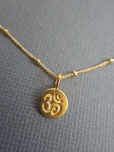 24K Gold Vermeil over Sterling Silver Om Charm on gold fill chain and clasp. *Om Pendant measures 7mm x 8mm ( small) **Available in Sterling Silver: https://www.etsy.com/listing/108134124/om-necklace-sterling-silver-om-pendant +OM is the sound of the vibrations of the Universe, and has been cooberated by quantum physicists. Loosely it means God, but not in the sense that Western religion defines god but as an awareness, a natual law of metaphysics, the collective conscious, the Self. ----------- Cheap Yellow Gold Spiritual Necklaces, Spiritual Yellow Gold Coin Necklace, Everyday Spiritual Yellow Gold Charm Necklace, Spiritual 14k Gold-filled Yellow Gold Charm Necklace, Spiritual 14k Gold Filled Yellow Gold Charm Necklaces, Spiritual Brass Charm Necklace With Coin Pendant, Spiritual Gold Coin Necklace In Brass, Spiritual Gold Round Coin Necklace, Gold Spiritual Coin Necklace