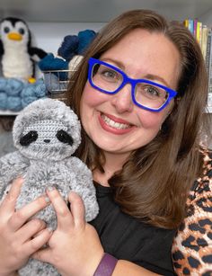 a woman wearing glasses holding a stuffed animal