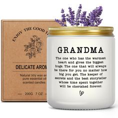 a white candle with purple flowers in it next to a cardboard box that says, grandma