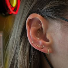 a close up of a person's ear with some piercings on top of it