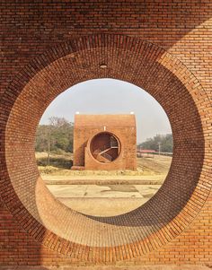 a brick wall with a circular hole in the middle that has a clock on it