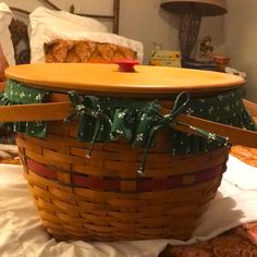 a wooden basket with green bows on the top and bottom, sitting on a bed