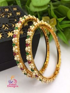 A pair of Extreme high quality gold plated pearl bangle with tiny round ruby and emerald stone work and in unique designs. Elegant Festive Bangle With Round Beads, Elegant Multicolor Bangle For Celebration, Festive Gold Pearl Bracelets, Bangles Gold Design, Festive Gold Pearl Bracelet, Festive Pearl Bangle Jewelry, Stone Bangles Gold, Traditional Pearl Bangle Bracelet, Hand Set Ruby Round Bangle