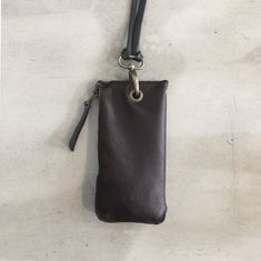 a brown leather pouch with a metal keychain hanging from it's side