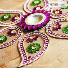 a close up of a decorative object on a wooden surface with beads and flowers in the center