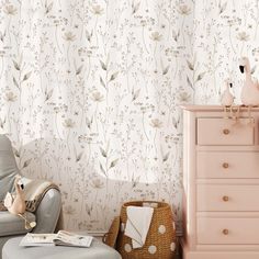 a baby's room with pink furniture and floral wallpaper