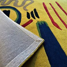 a yellow rug with blue and red designs on it