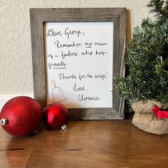 two christmas ornaments sitting on top of a wooden table next to a sign that says, don't worry