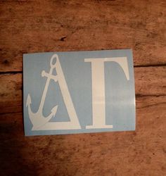 a blue and white sticker with an anchor in the center on a wooden surface