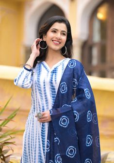 Grab this beautiful 3-piece set. The set comes with straight cut tie dye kurta has v neck, 3/4th sleeves & calf length teamed with printed trouser pants and a printed chanderi cotton dupatta to match. Color - Blue & White Kurta Fabric-Viscose Pant Fabric-Viscose Dupatta Fabric- Chanderi Cotton Neck-V Neck Sleeves-3/4th Sleeves Work - Tie Dye & Print Detailing Washing Instructions-Dry Clean Model Height - 5.5 wearing size small. DISCLAIMER - The color of the product may be differ due to screen se Bandhani Print Straight Kurta Sets For Summer, Summer Bandhani Print Sets With Straight Kurta, Traditional Indigo Sets For Summer, Bohemian Bandhani Print Sets For Spring, Blue Bandhani Print Sets For Summer, Unstitched Bandhani Print Kurta For Summer, Cotton Sets With Batik Print For Festivals, Festive V-neck Bandhani Print Sets, Festive Bandhani Print V-neck Set