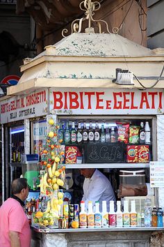 a man standing in front of a food stand