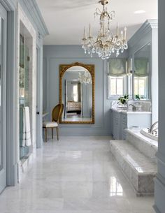 a large bathroom with a chandelier and marble flooring in the middle of it