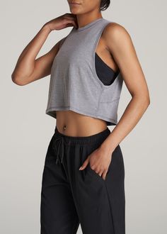 About Our Women's Tall Cropped Muscle Tank Having the right gear makes a difference. Everything about our athletic tank is made to help you smash your workout goals. Constructed with rayon and spandex, this tank won't slow you down. Our women's tall tank has been carefully crafted for women 5'9 to 6'6. Its cropped length ends just above the natural waist and its oversized armhole allows for maximum movement for a distraction-free workout. This athletic tank for tall women has been pre-washed and Cheap Camisole Tank Top For Workout, Muscle Tee Women Outfit, Cheap Collegiate Sports Tank Top, Muscle Tank Outfit Women, Muscle Shirt Outfit Womens, Sleeveless Tshirt Outfit, Outfits For Muscular Women, Athletic Outfits For Women, Tank Top Outfits Aesthetic