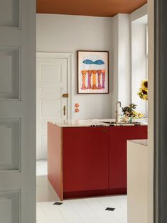 a kitchen with red cabinets and white floors