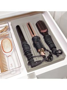 an open drawer with hair brushes and combs