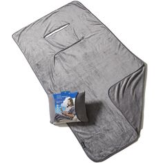 a gray blanket with a pillow on top of it and a magazine laying next to it