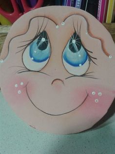 a child's face painted on the side of a pink plate with blue eyes