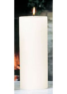 a white pillar candle with a lit candle in front of a fire place on a table