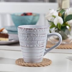 a white coffee cup sitting on top of a table