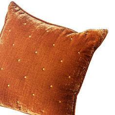 a brown pillow with gold dots on it