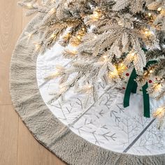 a white christmas tree skirt with green ribbon